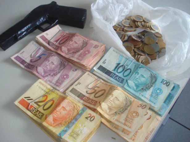 Dinheiro e simulacro apreendido com o acusado de roubar agências dos Correios